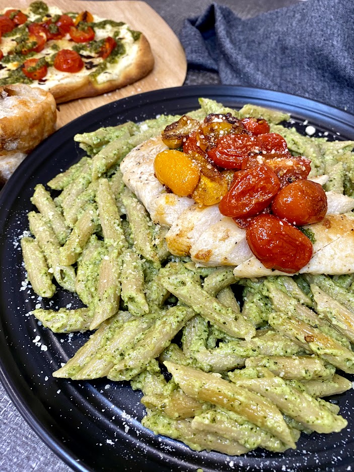 Creamy Pesto Pasta topped with chicken, cherry tomatoes and parmesan cheese